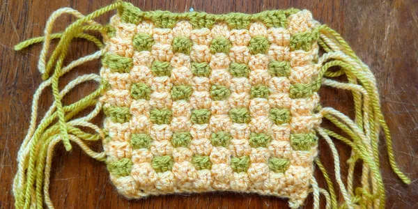 4 example swatches of the interlocking granny stitch in various colors and yarn weights