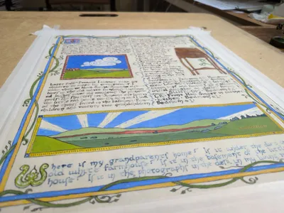 Photo of a rough draft of "Attachment", made on regular paper. The size of the final paper and guidelines for the writing are drawn in calligraphy, a draft of the text has been written with quill & ink, rough drafts of the illustrations are painted in. There's a big empty space, a spot where the black text has been written on top of with blue, and lots of pencil notes in the margins.