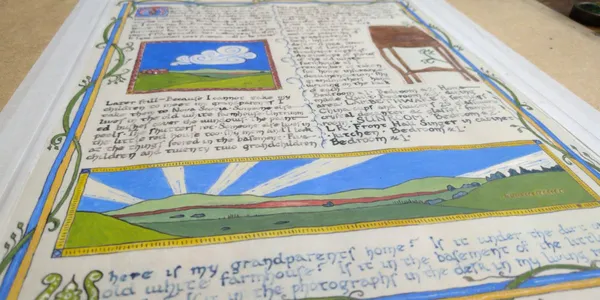 Photo of a rough draft of "Attachment", made on regular paper. The size of the final paper and guidelines for the writing are drawn in calligraphy, a draft of the text has been written with quill & ink, rough drafts of the illustrations are painted in. There's a big empty space, a spot where the black text has been written on top of with blue, and lots of pencil notes in the margins.