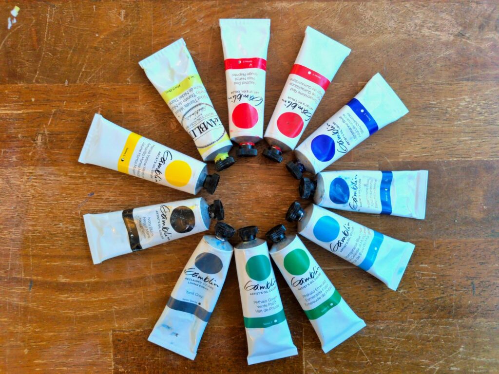 Picture of paint tubes laid out in a vaguely color-wheel fashion. Gosh, I wonder what pigments are in these Gamblin oil paints?